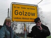Filmemacher Barbara und Winfried Junge am Ortsschild von Golzow